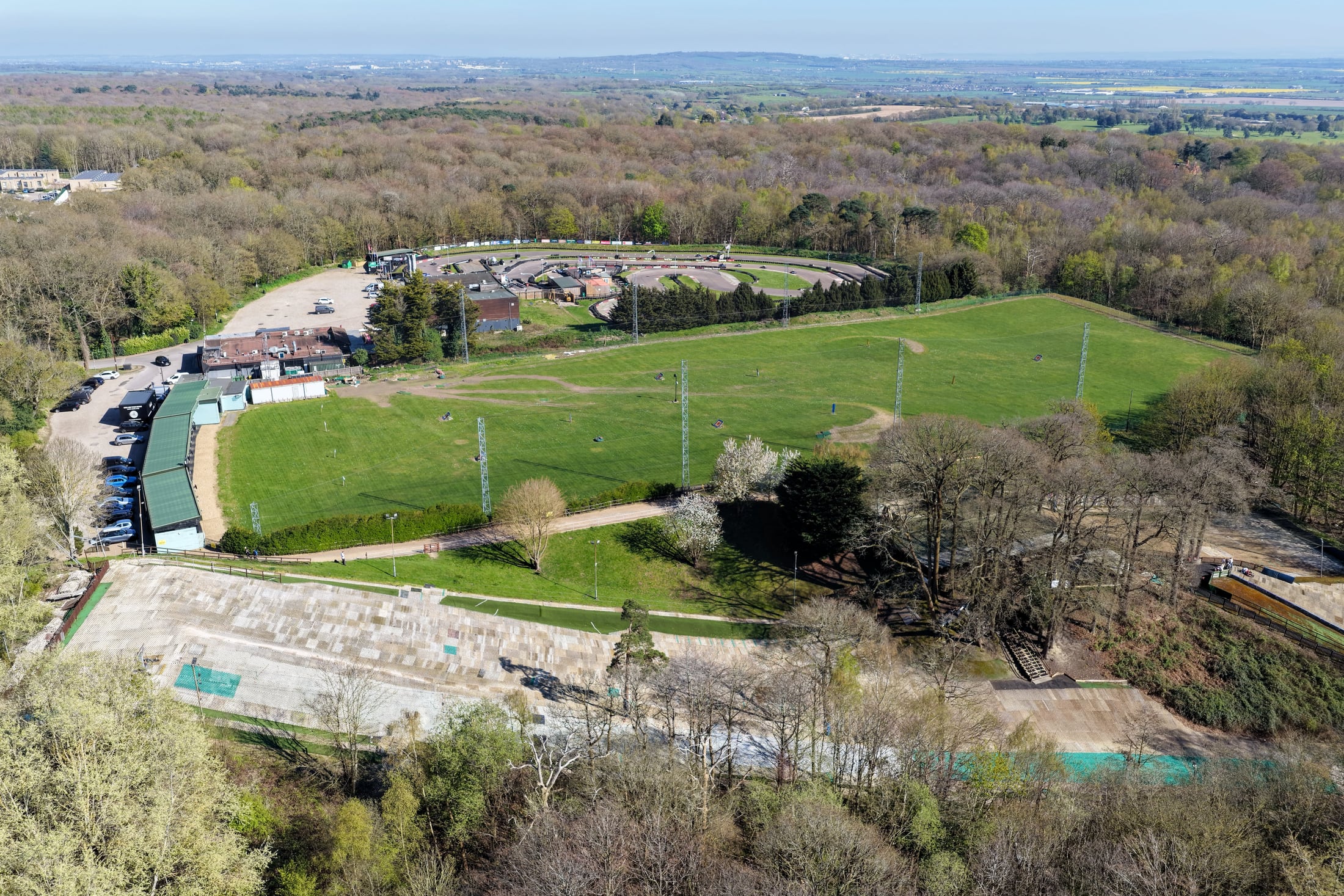 Aerial view of sports fields, woodland and a nearby activity venue